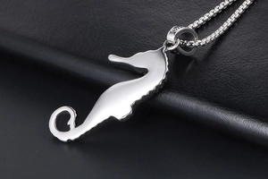 Macro view of polished stainless steel seahorse pendant on a classic box chain