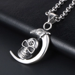 Gothic silver moon and skull pendant necklace on black leather background