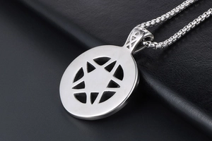 Detailed macro view of silver stainless steel hollow pentagram pendant on black leather