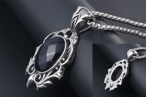 Macro detail of teardrop blue sandstone pendant with retro hollow vine metal patterns
