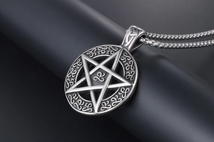 Macro shot of retro stainless steel star pendant with Celtic knot details on black pedestal