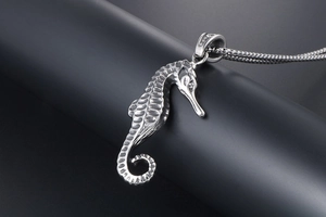 Detailed close-up of a silver seahorse pendant with intricate scale textures on a metal chain