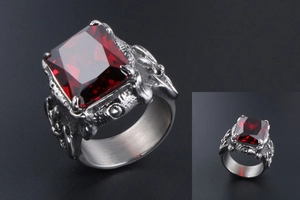 Detail of vintage silver titanium steel ring with ruby inlay and dragon claw relief