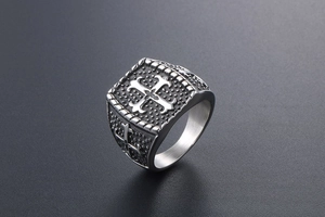 Makroaufnahme eines Vintage-Siegelrings aus Titanstahl mit geprägtem Kreuz auf der Fläche
