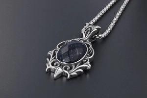 Macro view of blue sandstone pendant with baroque silver metal carvings and box chain