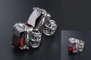 Detailed view of men's titanium ring with red gemstone and gothic cross engravings