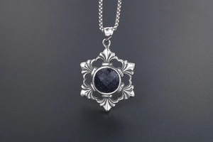 Detail of a square box chain and silver pendant with faceted blue goldstone inlay