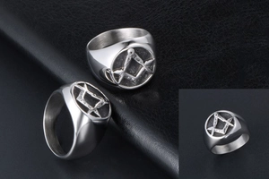 Detailed close-up of silver Masonic ring with square and compass over black matte background