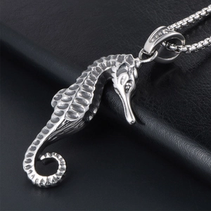 Detailed seahorse pendant crafted in silver stainless steel on a black leather surface