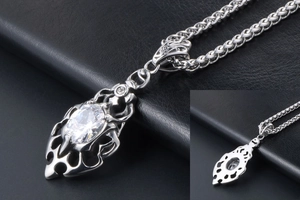 Detailed view of silver flame gothic pendant with oval clear gemstone on wheat chain