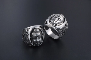 Détail macro du visage de Bouddha gravé et des motifs de lotus sur bague en acier titane
