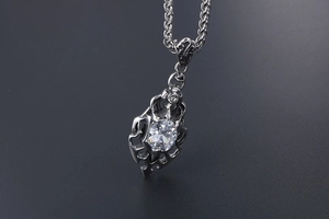 Macro shot of silver flame pendant with large oval gemstone and gothic镂空 detailing