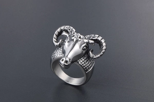 Detailed close-up of a vintage ram head ring featuring intricate spiral horns and punk style