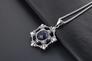 Macro detail of gothic titanium steel pendant with blue sandstone and vintage patterns
