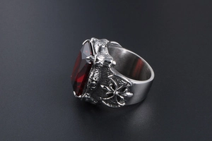 Detailed close-up of gothic men's ring featuring a red ruby-like stone and dragon claw design