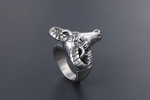 Detailed close-up of a vintage ram head ring with spiral horns in punk rock silver finish