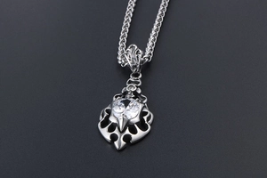 Close-up of flame-shaped steel pendant with a brilliant round-cut central zircon stone