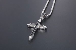 Detail of a double-layered cross pendant with black inlay on a steel pearl chain