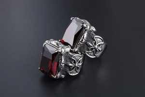 Macro shot of silver gothic rings featuring inlaid rectangular red gemstones and crosses