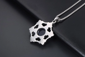 Macro shot of silver snowflake pendant with blue sandstone and heart cutouts