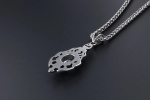 Macro side view of silver hollowed pendant with round sparkling gemstone and twisted chain
