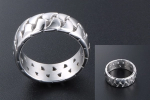 Close-up of industrial silver woven chain ring with internal triangle cutout design