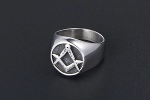 Macro detail of retro stainless steel Freemasonry signet ring with engraved square and compass