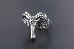 Macro shot of silver goat head ring with curved horns and geometric side textures