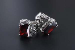 Detail of gothic steel ring showing ruby stone, dragon claw setting and cross relief