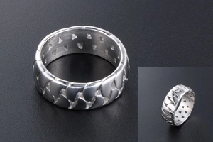 Macro detail of men's wide chain ring with hollow design and brushed steel finish