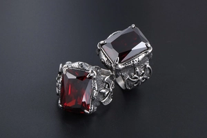 Detail of gothic titanium steel ring with ruby gemstone and dragon claw engravings