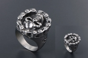 Close-up of vintage punk skull ring with bike chain border and cross engraving