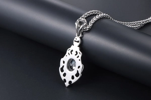 Macro view of stainless steel flame pendant back with wheat chain and clear gemstone