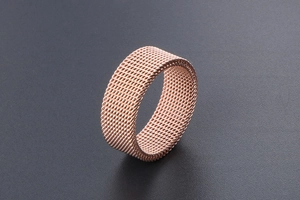 Close-up of rose gold titanium steel mesh ring showing industrial woven texture detail