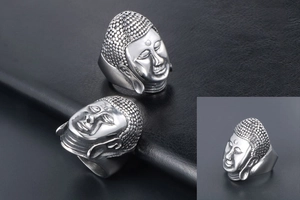 Macro detail of silver Buddha head ring showing intricate facial carving and hair texture