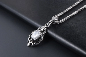 Close-up of gothic flame pendant with oval zircon on black leather background