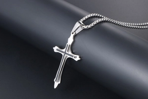 Macro shot of silver titanium steel cross pendant with black inlay on a round chain