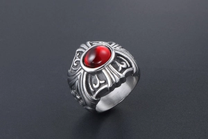Macro view of gothic silver titanium ring featuring oval red gemstone and carved details