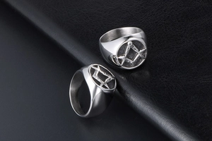 Detail shot of heavy masonic square and compass logo on silver stainless steel rings