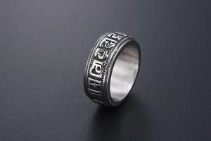 Macro detail of titanium steel punk ring with embossed mantra and retro silver finish