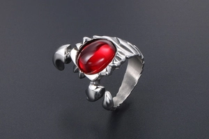 Macro shot of silver scorpion ring featuring a red oval stone and punk metallic details