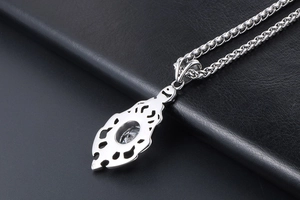 Close-up of flame-shaped pendant back with hollow design and inlaid crystal gem