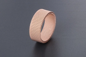 Macro shot of rose gold woven mesh band ring showcasing intricate titanium steel texture