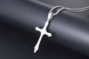 Side view of silver stainless steel cross pendant on black cylindrical display