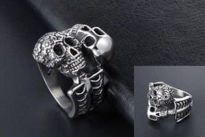 Detailed macro view of silver twin skull ring with intricate Mexican floral engraving
