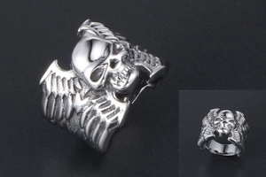 Vue latérale macro d'une bague tête de mort gothique avec texture d'ailes et métal argenté