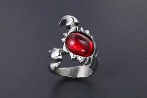 Macro shot of a men's titanium steel scorpion ring with a large red oval stone