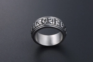 Macro shot of titanium steel ring featuring embossed Sanskrit Six-Syllable Mantra text
