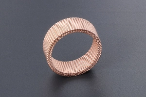 Detailed macro view of rose gold woven mesh ring texture with smooth inner band