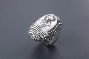 Close-up of embossed Buddha head details on silver titanium steel ring for men